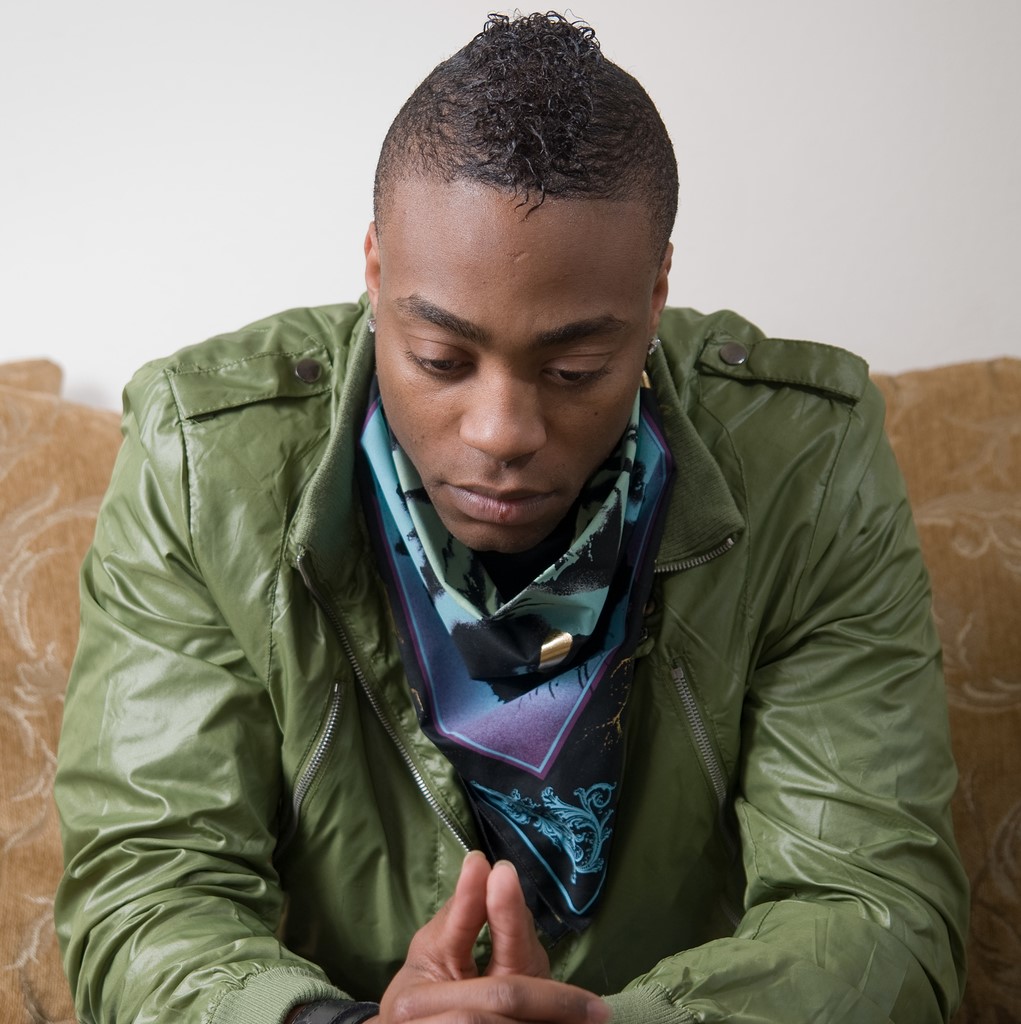 African American man in green jacket looking concerned